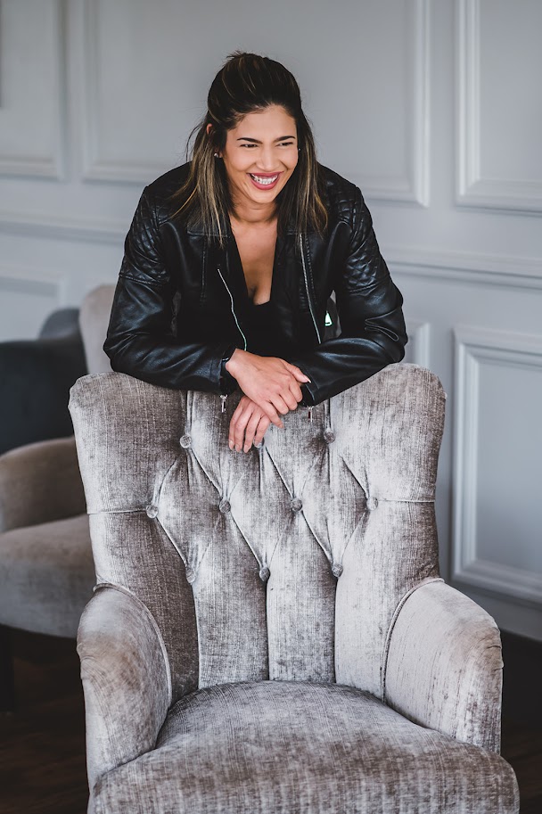 Freya Jones smiling, leaning on a velvet armchair